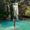 man swimming in waterfall